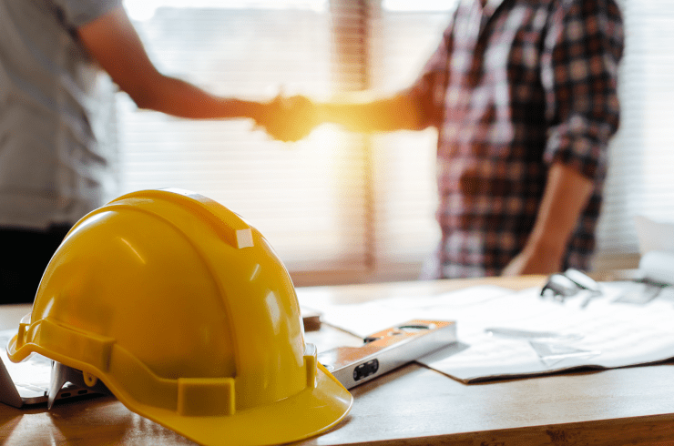 Aperto de mão com um capacete de construção na página sobre nós